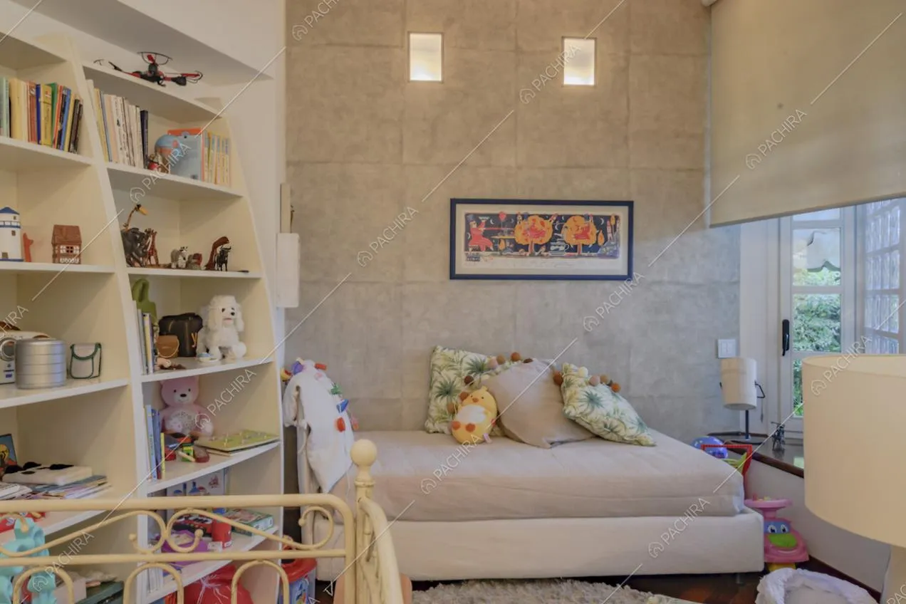 Scaffale bianco e letto con cuscini e peluche