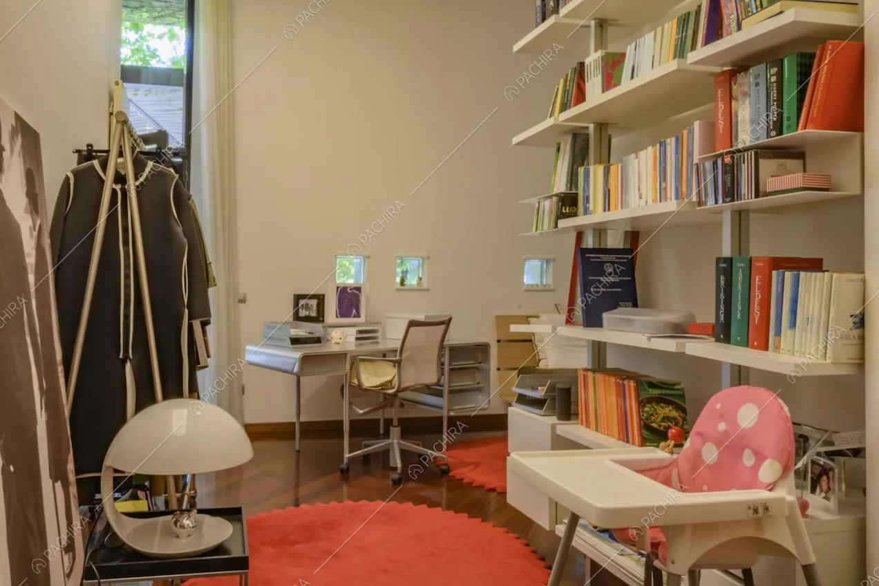 Scrivania con sedia e libreria piena di libri