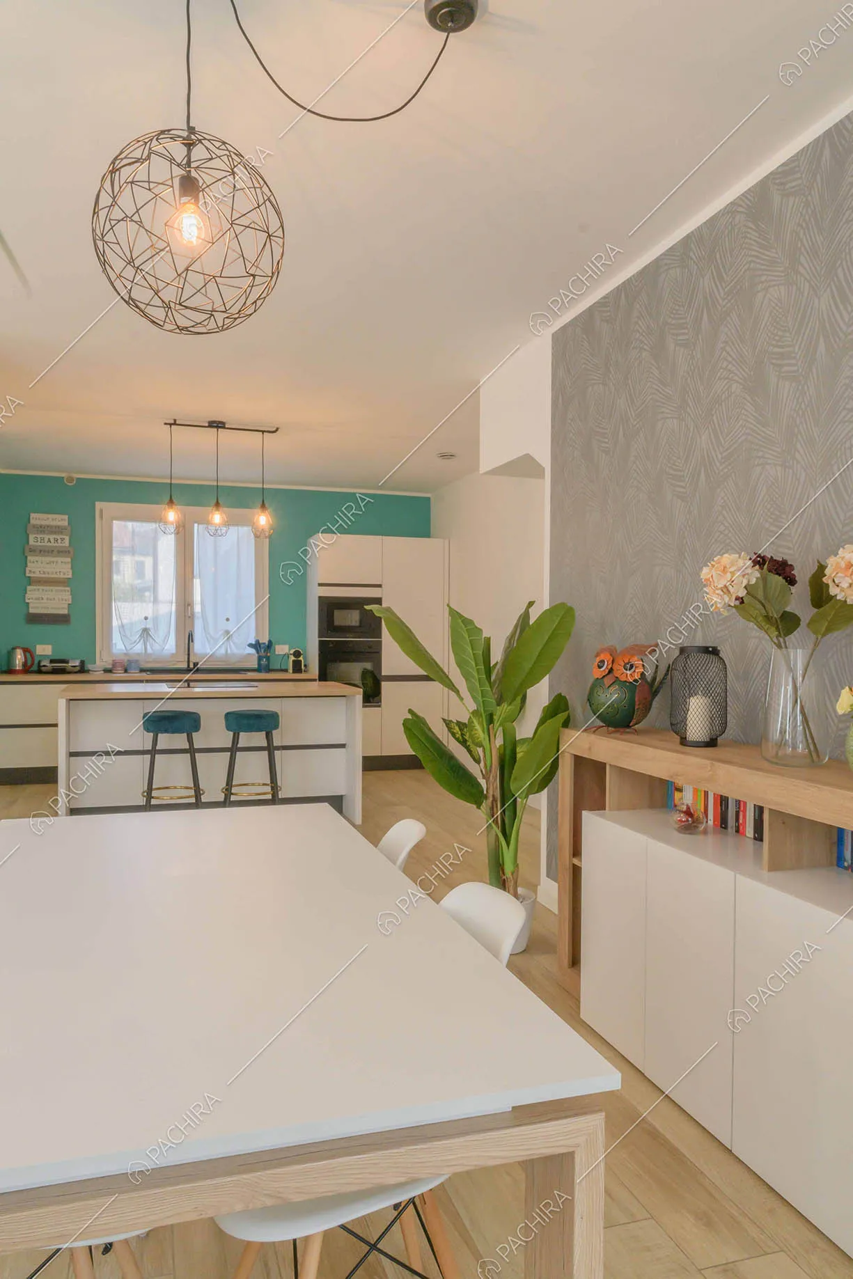 Tavolo da pranzo bianco nella sala con pavimento in parquet e carta da parati grigia