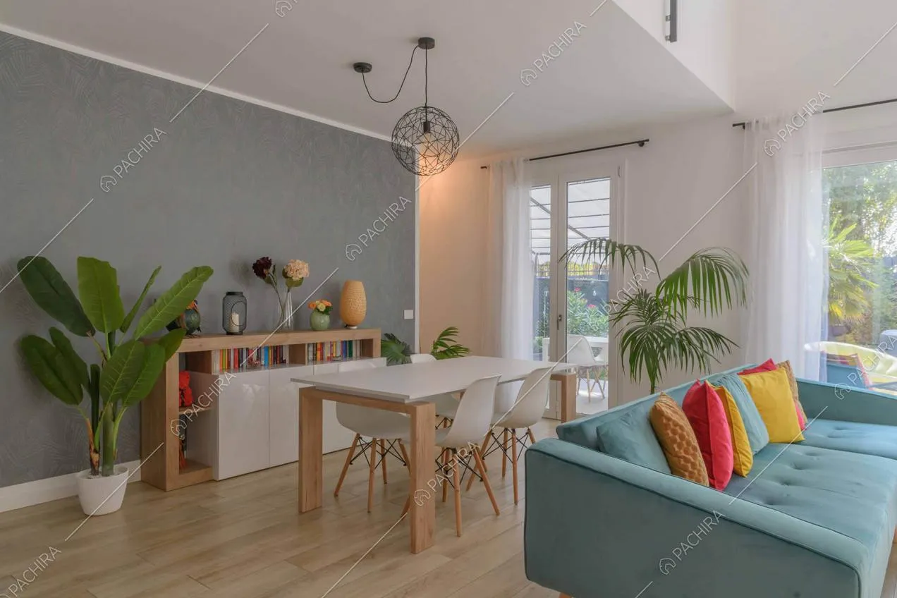 Sala con tavolo da pranzo, pavimento in parquet e carta da parati grigia