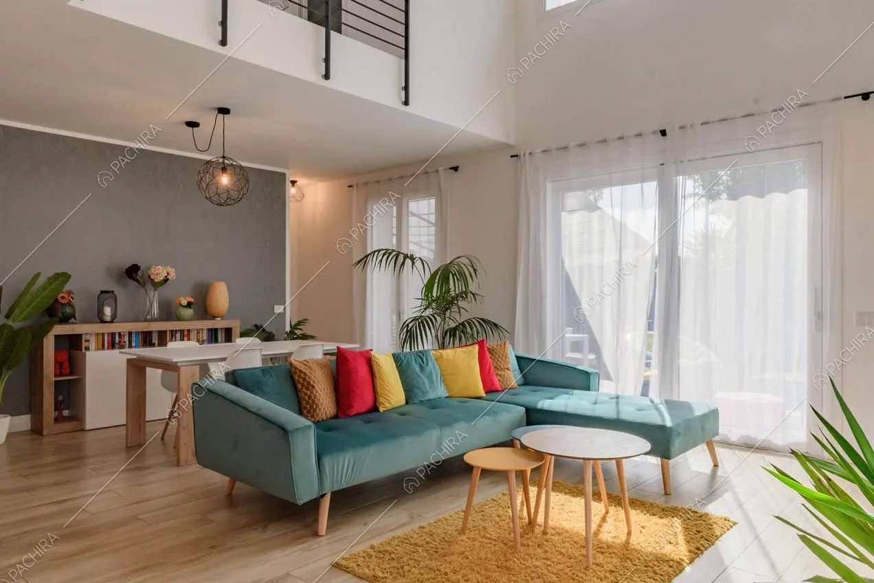 Sala con pavimento in parquet, divano in velluto blu e porte-finestre