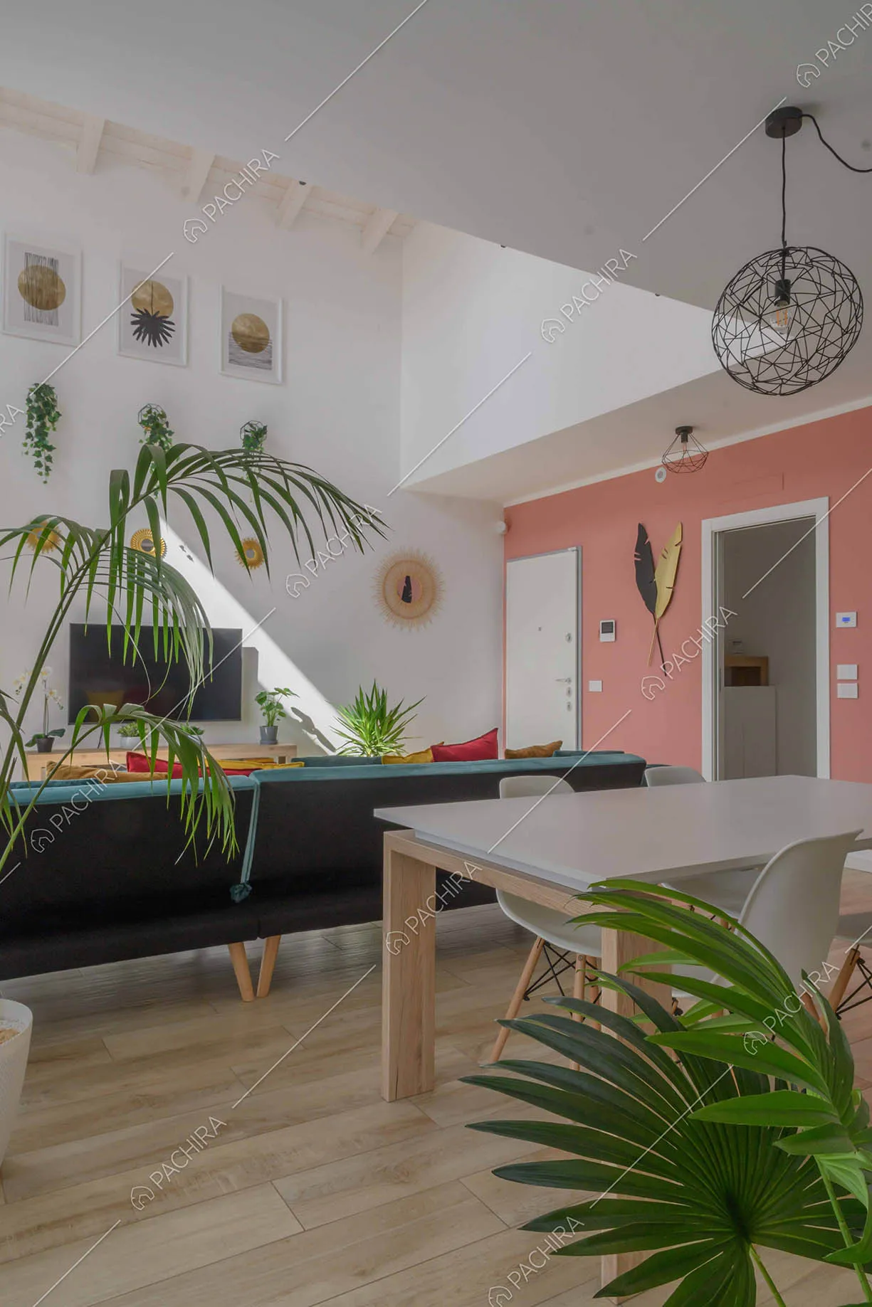 Tavolo da pranzo bianco nella sala con pavimento in parquet e divano in velluto