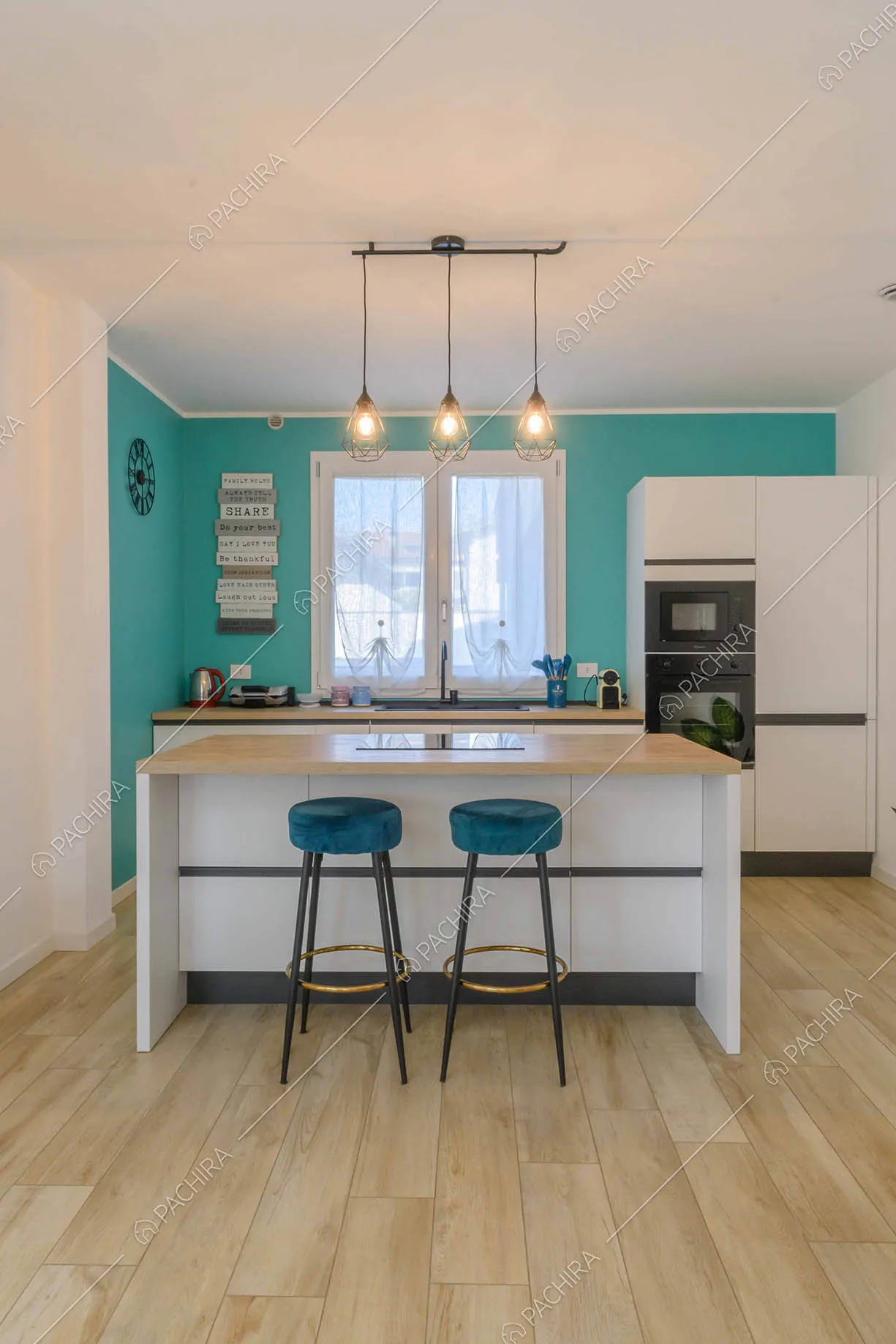 Cucina a isola bianca con sgabelli alti in velluto blu e pavimento in parquet