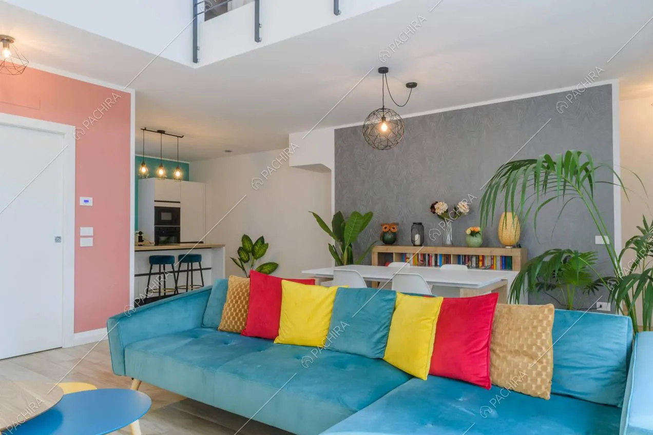 Sala con soppalco, divano azzurro in velluto e pavimento in parquet