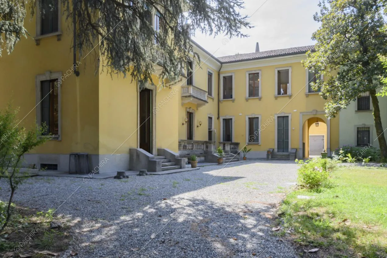 Esterni gialli della dimora storica con pavimentazione in ghiaia