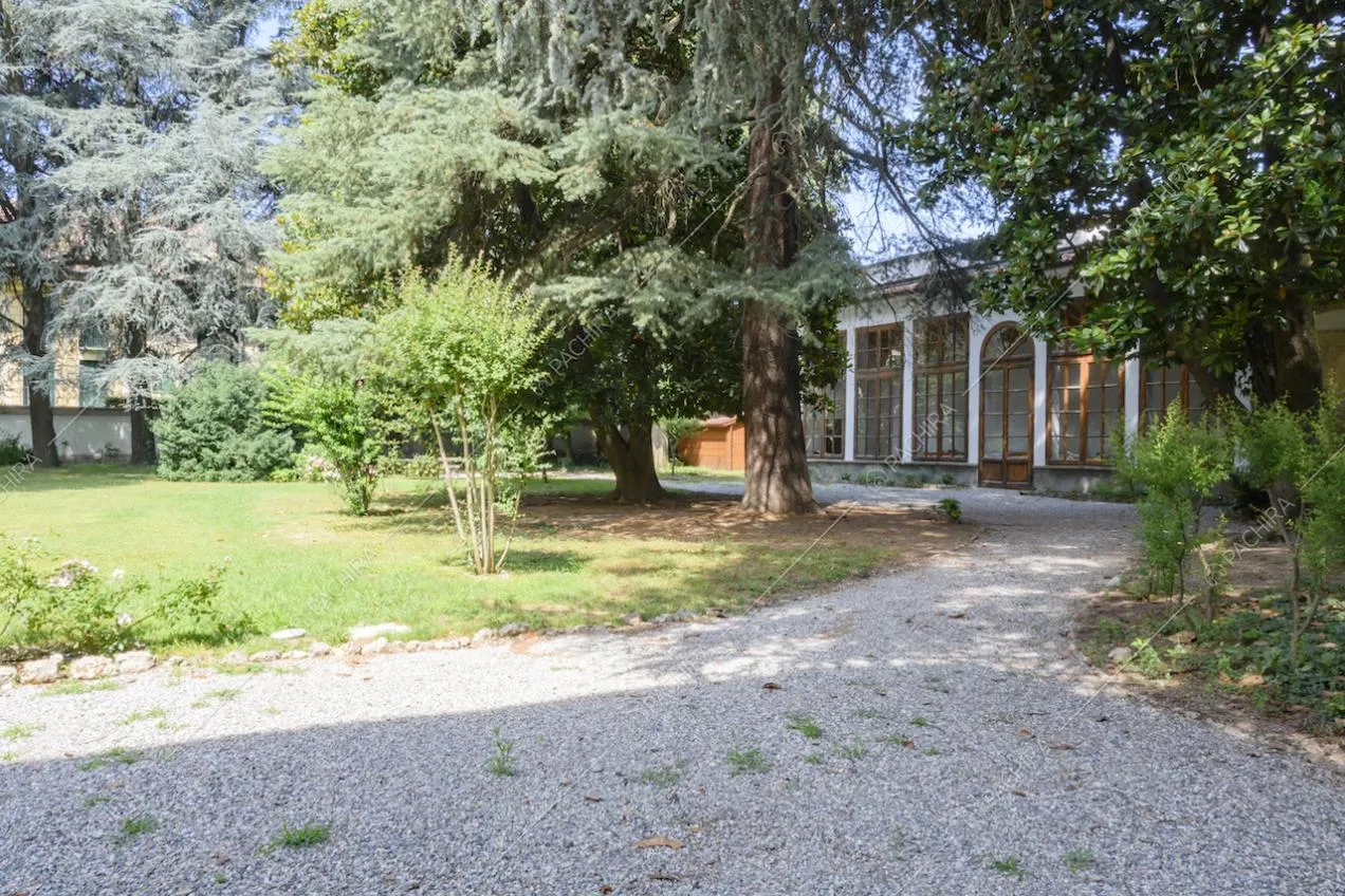Giardino con alberi sempreverdi e scorcio sulla limonaia