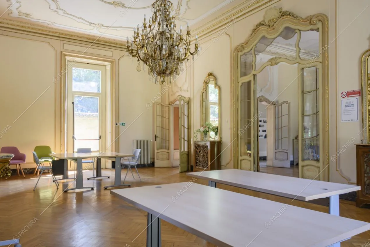 Ampio salone in stile classico sui toni del giallo, pavimento in parquet a spina di pesce e coprifili lavorati