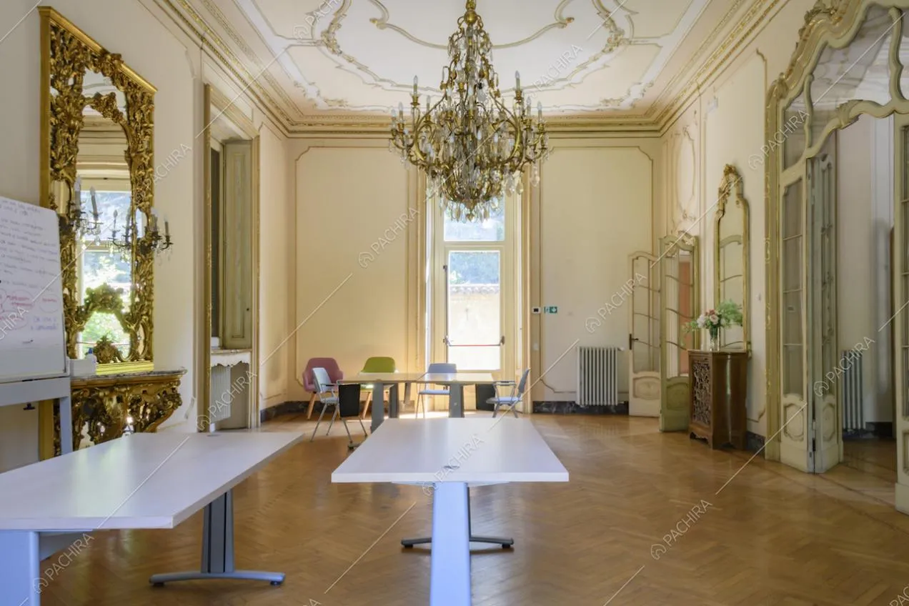 Salone con lampadario antico, pareti e soffitto con boiserie e porte in vetro e legno lavorato