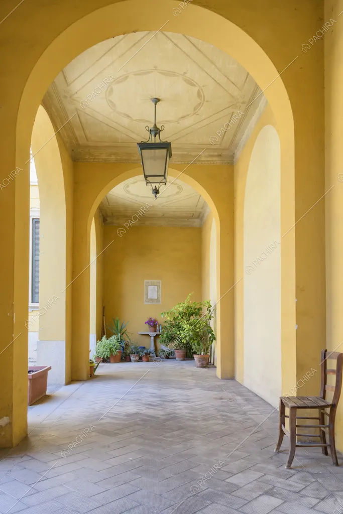 Portico giallo con volte ad arco, boiserie sul soffitto e pavimento a spina di pesce