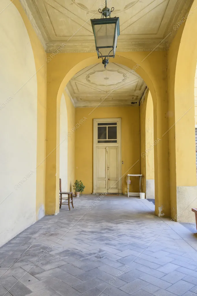 Portico sui toni del giallo con volta ad arco e boiserie sul soffitto