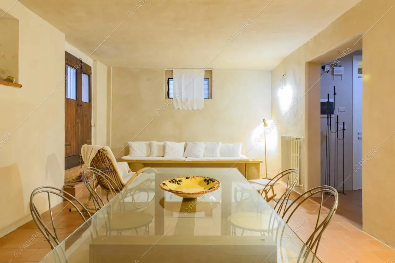 Sala con tavolo da pranzo, divano e pavimento in cotto