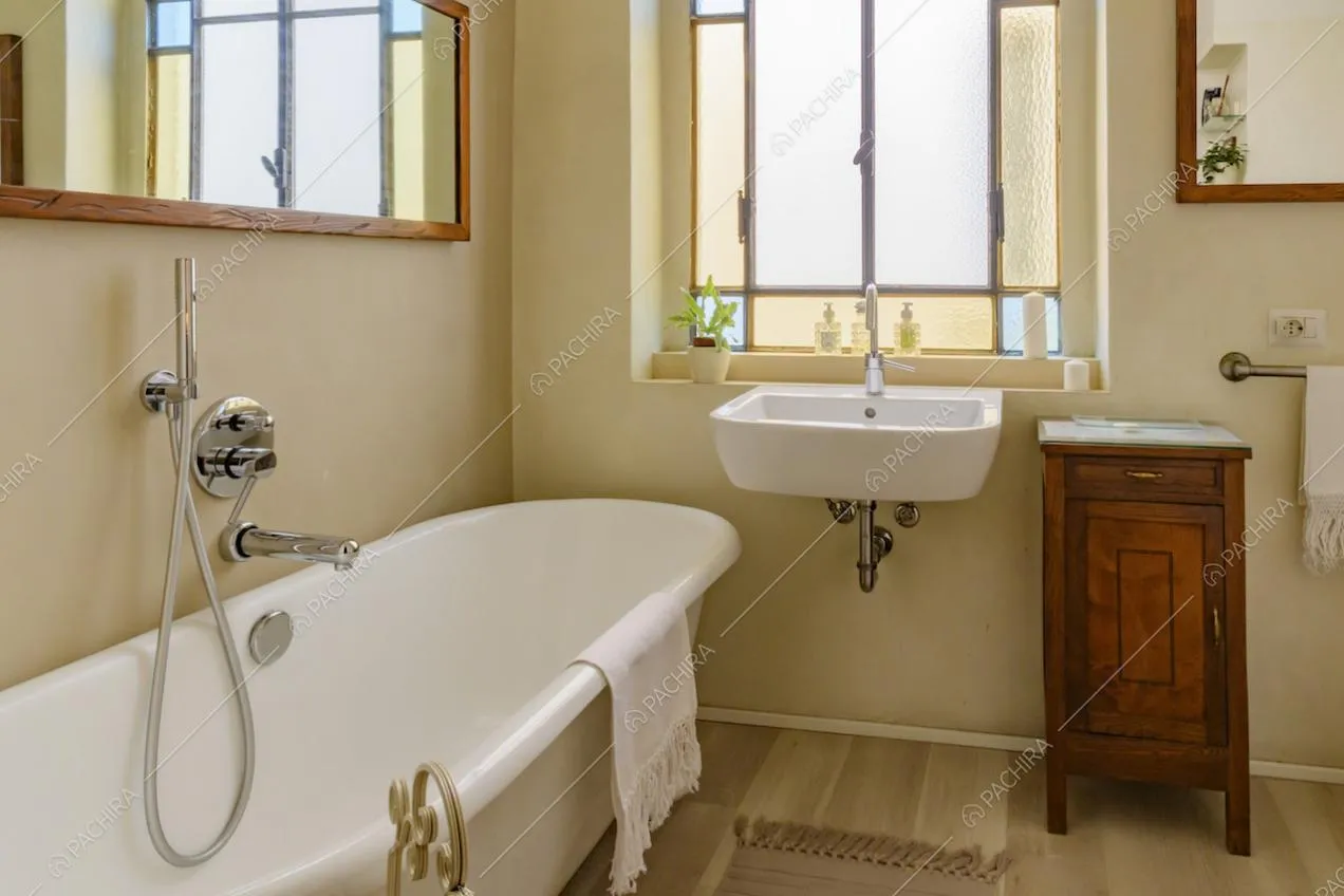 Luminoso bagno con vasca, pavimento in parquet e pareti beige