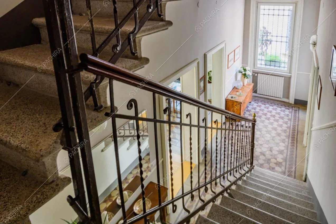 Dalle scale che conducono al piano superiore scorcio sulla zona living con pavimento in parquet