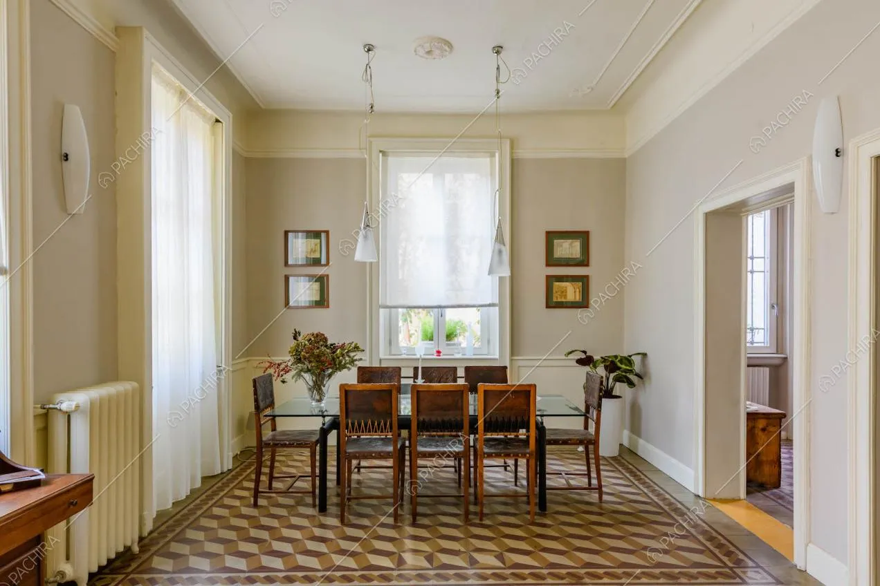 Tavolo da pranzo nella zona living con pavimento in marmo con fantasia geometrica