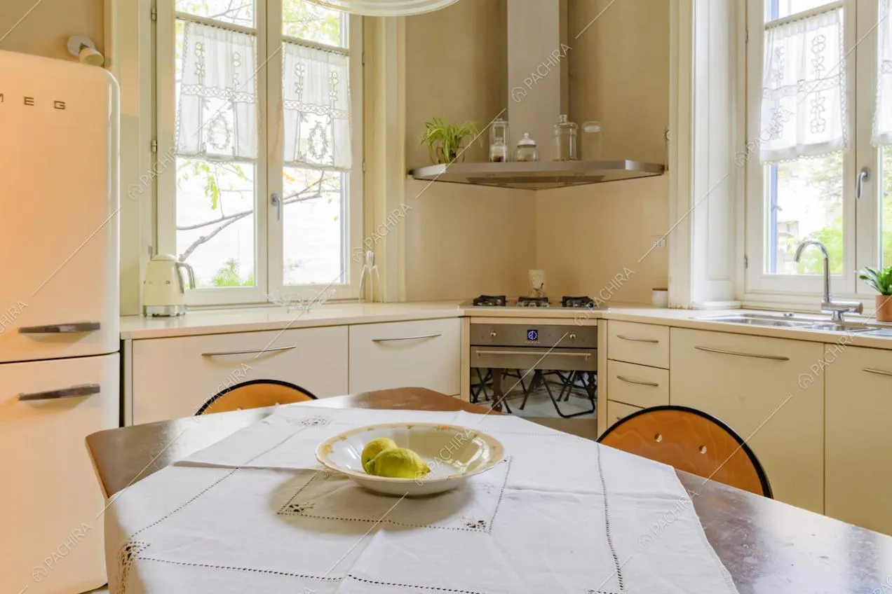 Tavolo da pranzo in legno nella cucina angolare a parete con fornelli a gas