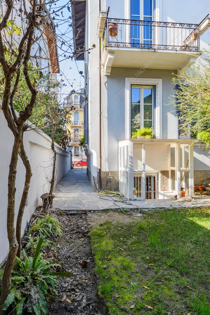 Dal giardino con rampicanti vista sugli esterni della villa