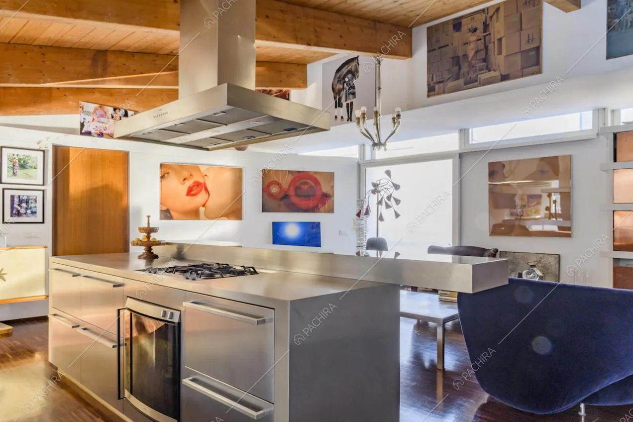 Cucina metallizzata con cappa e travi a vista in legno 