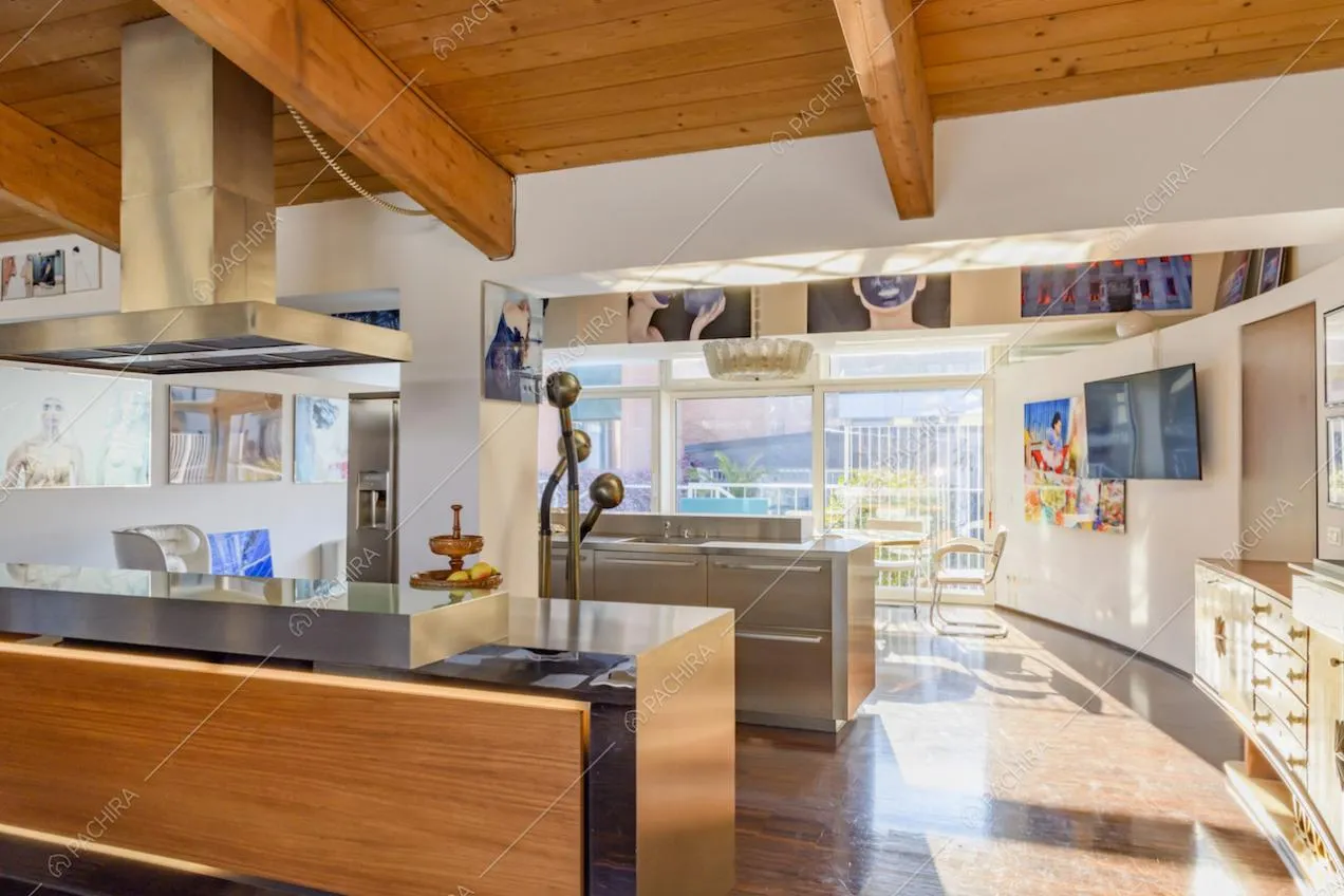 Cucina a isola con mobili metallizzati e in legno 