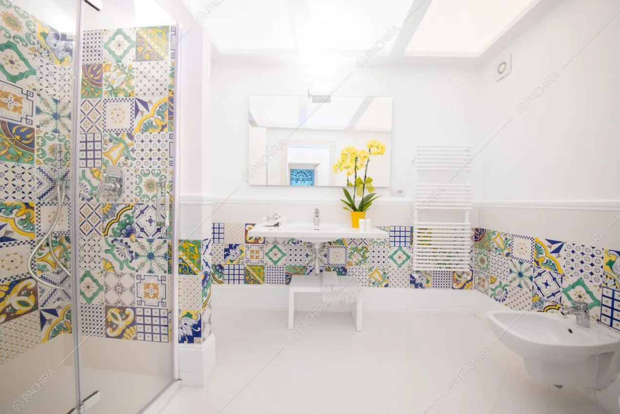 Bagno con arredi bianchi e cementine colorate