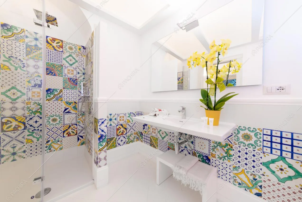Cementine sulle pareti del bagno e arredi bianchi
