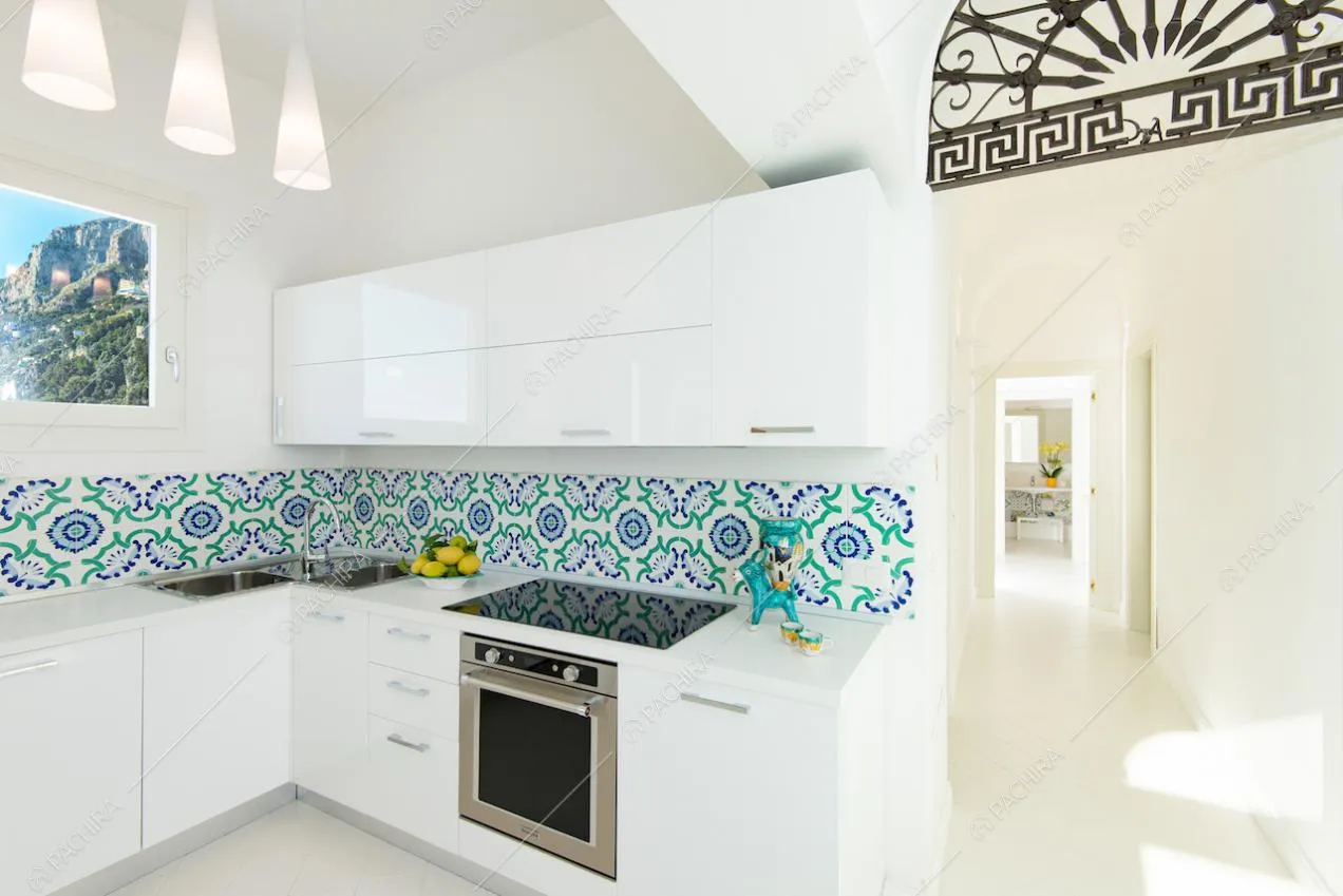 Cucina a parete bianca con piastrelle decorative sulla parete