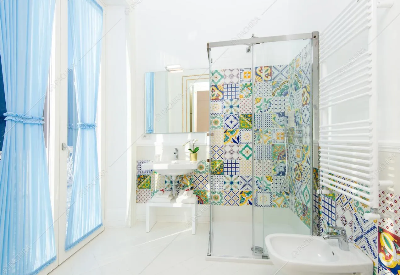 Bagno con doccia, specchio, sanitari e tende azzurre
