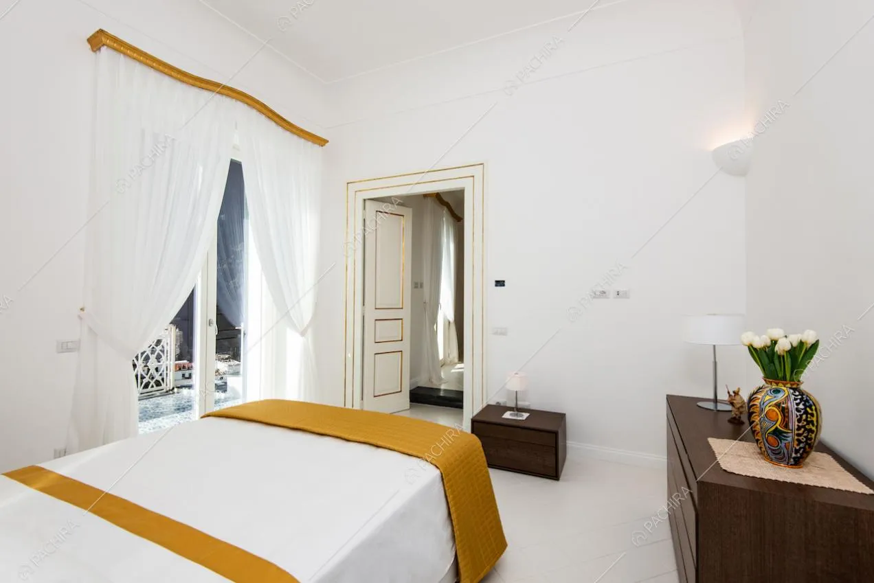 Mobili in legno scuro e pareti bianche nella camera da letto