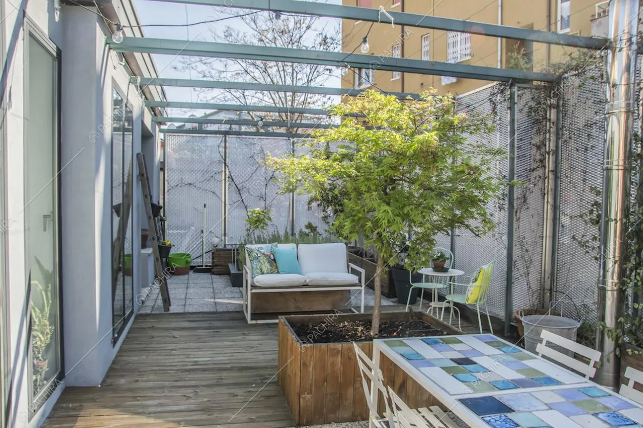 Terrazza con pavimento in parquet e piastrelle, tavolo da pranzo e divanetto