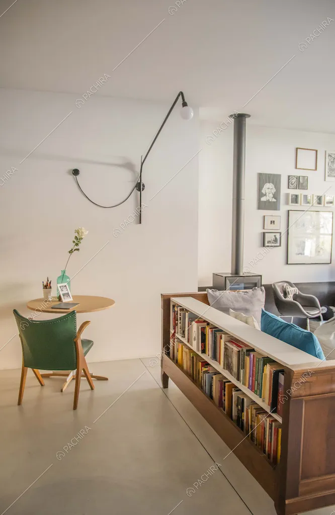 Soggiorno con pavimento in cemento lisciato, pareti bianche e illuminazione di design