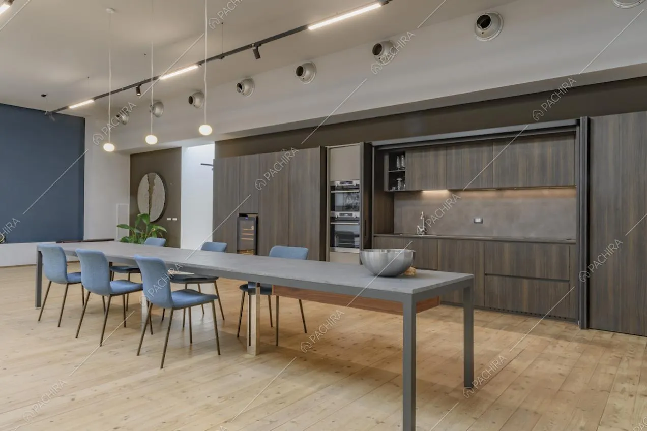 Lungo tavolo da pranzo nel salone con cucina in legno a vista