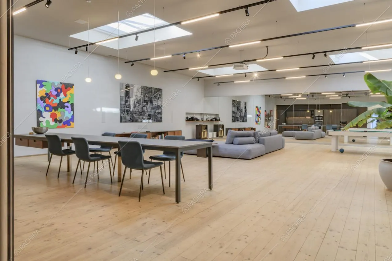 Ampio open space con pavimento in parquet e illuminato da lucernari