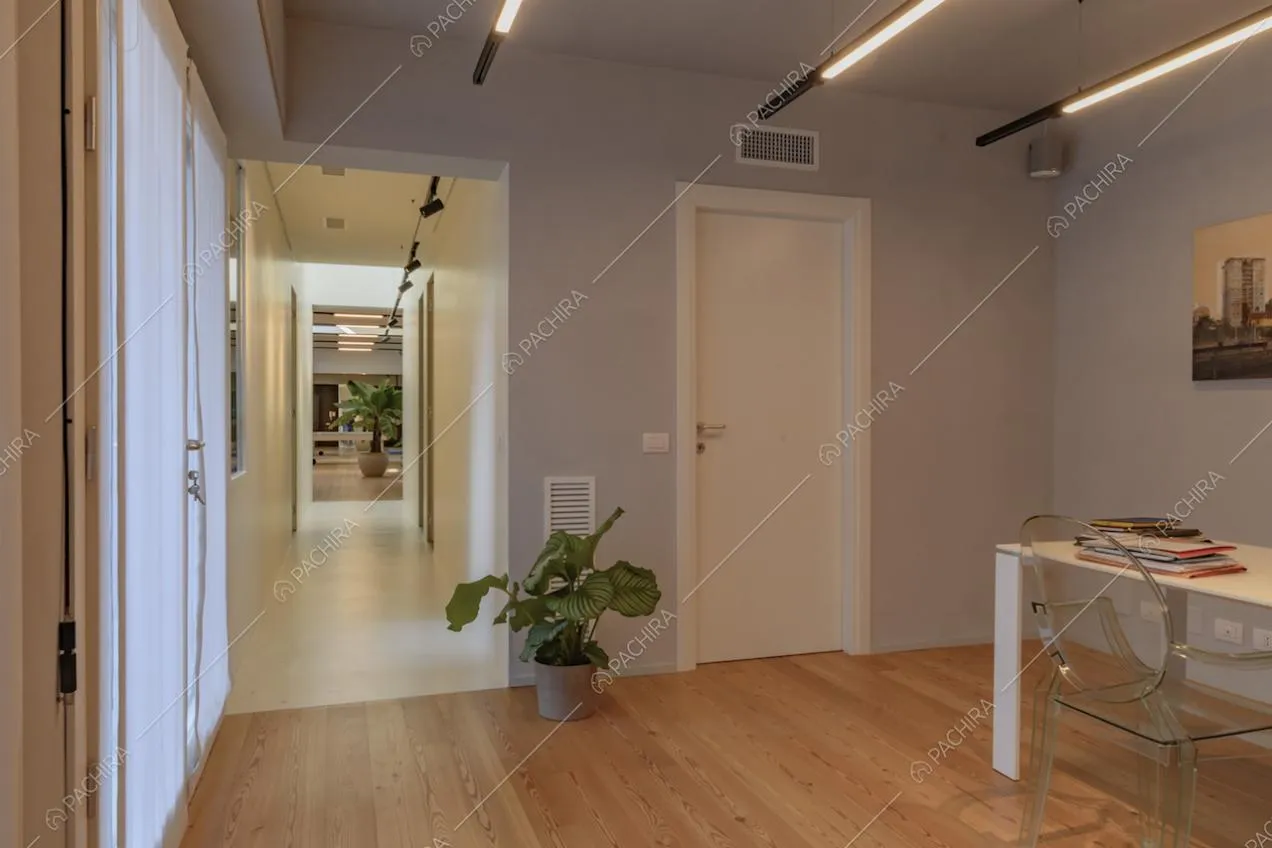 Dallo studio vista sul corridoio con pavimento bianco e sulla sala
