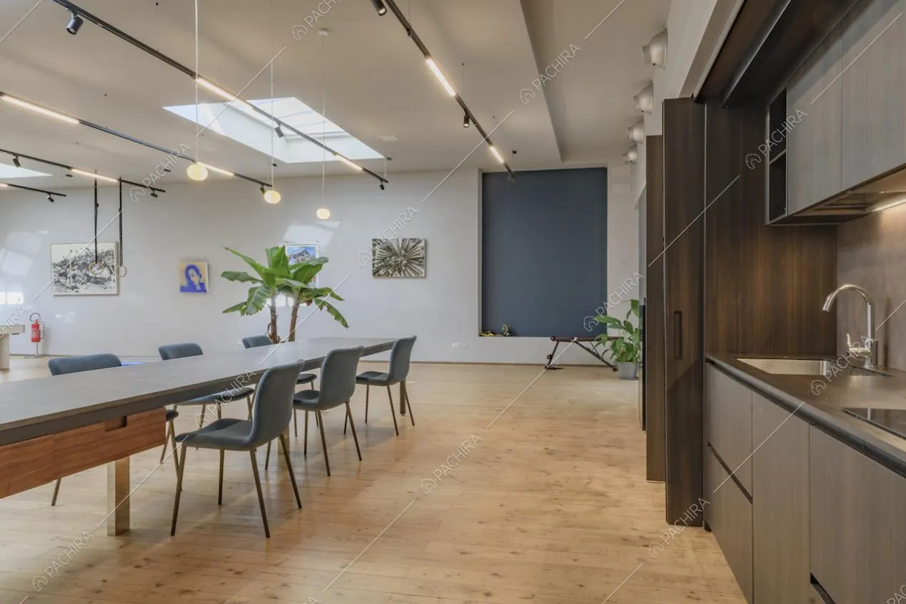 Cucina in legno con fornelli a induzione, pavimento in parquet e tavolo