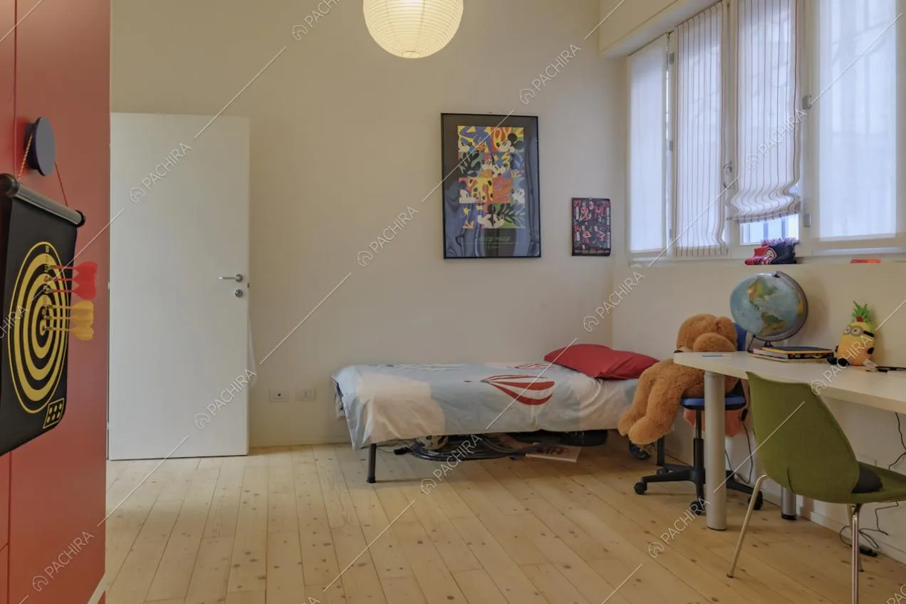 Ampia camera da bambini con pavimento in parquet, scrivania e letto singolo