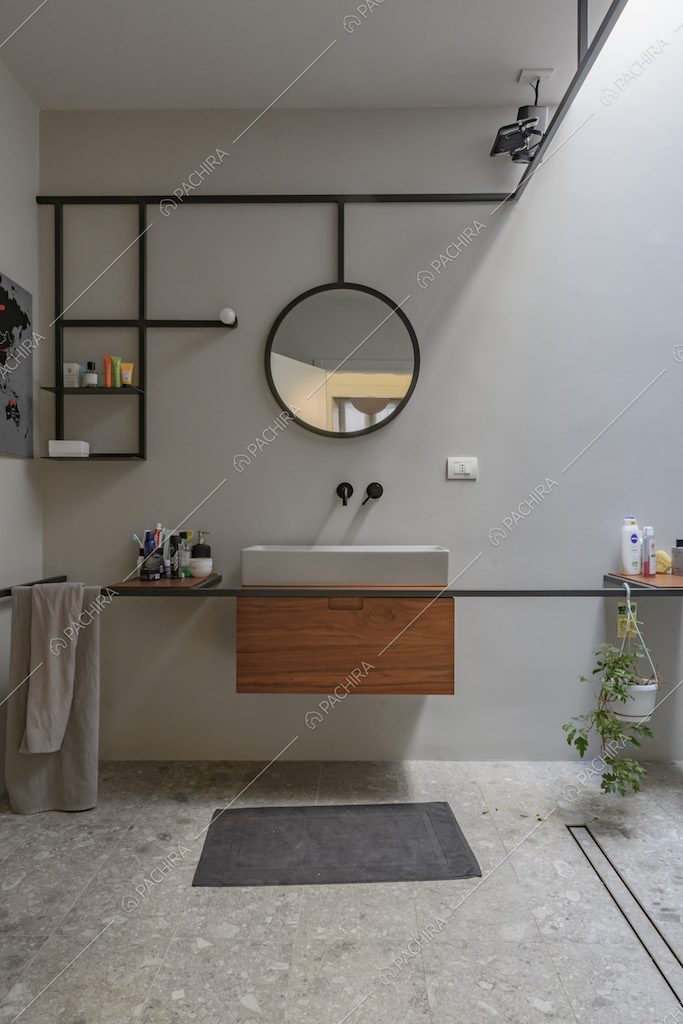 Mobile bagno sospeso in legno e ripiani di design nel bagno dalle pareti bianche