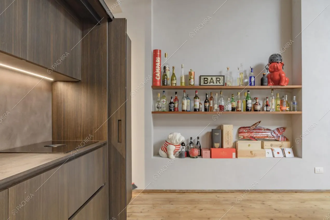 Cucina con piano da lavoro in legno, fornelli a induzione e parete bianca