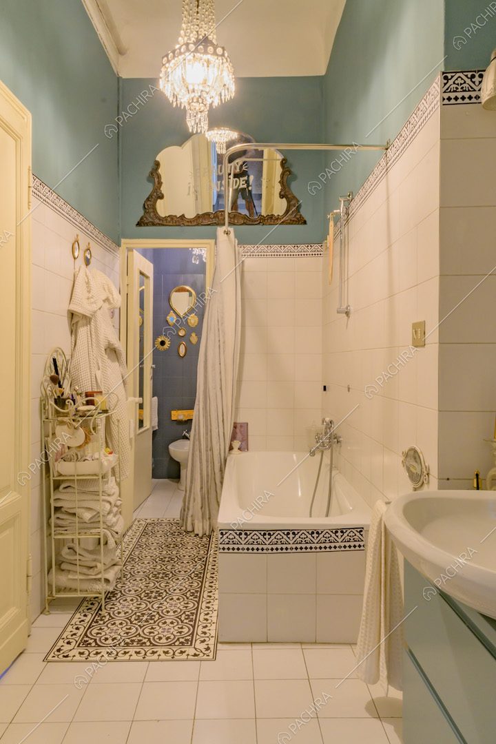 Bagno con pavimento e pareti a piastrelle bianche, vasca da bagno e pareti azzurre