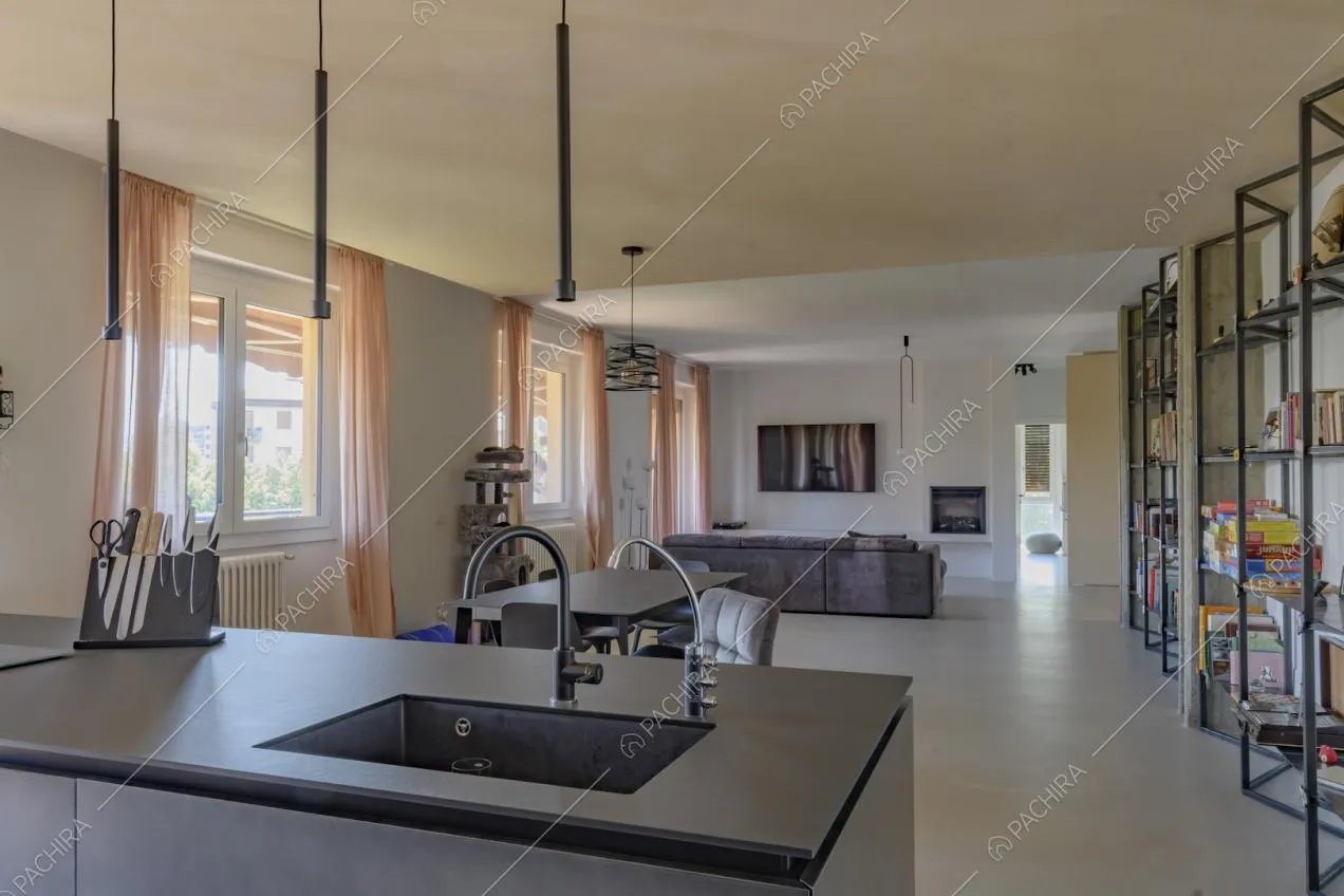 Lavandino sull'isola nera della cucina e vista sulla zona living