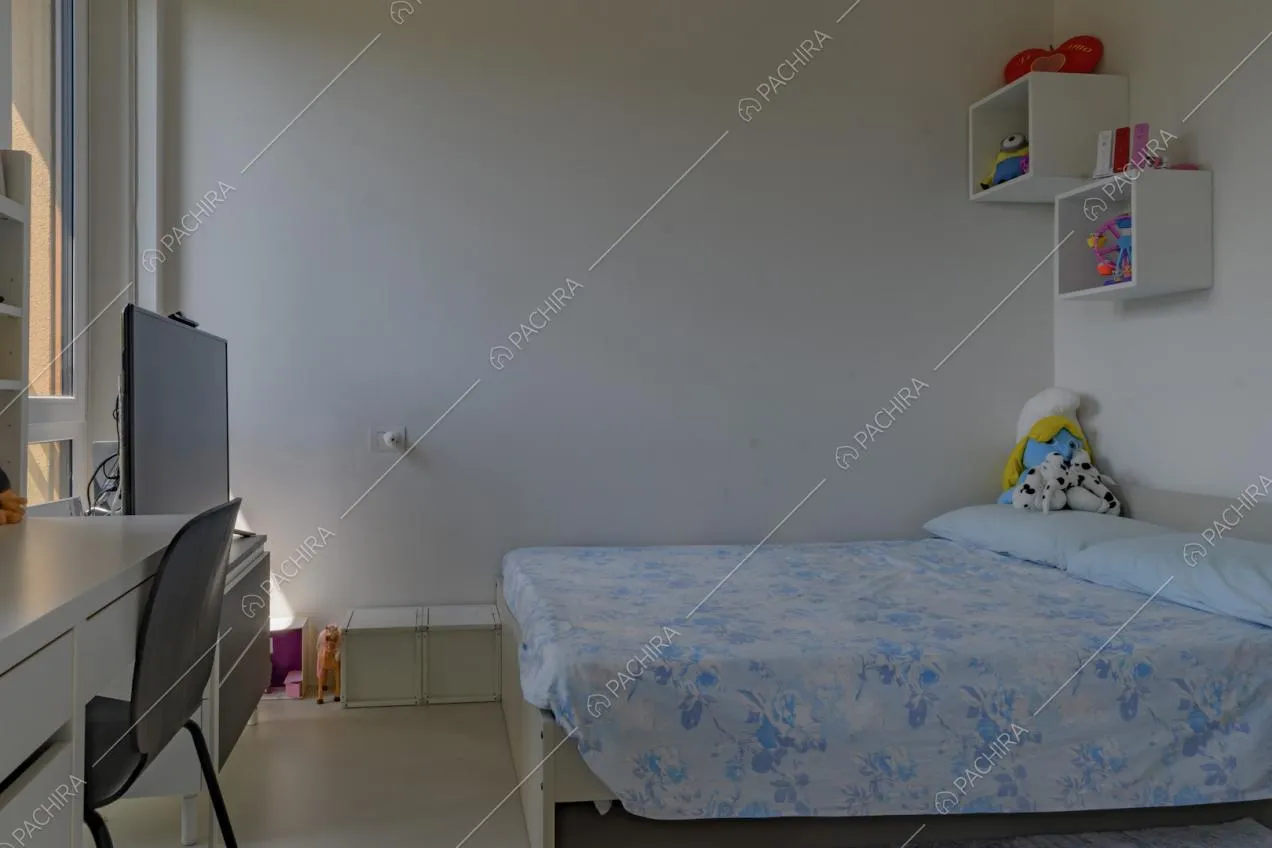 Camera da letto da bambini con pareti e scrivania bianche e pavimento in cemento lisciato
