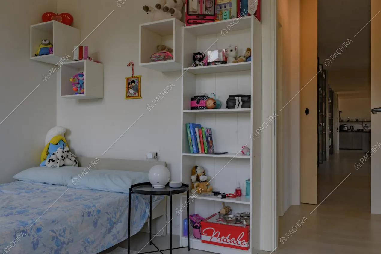 Camera da bambini con pareti bianche e pavimento in parquet