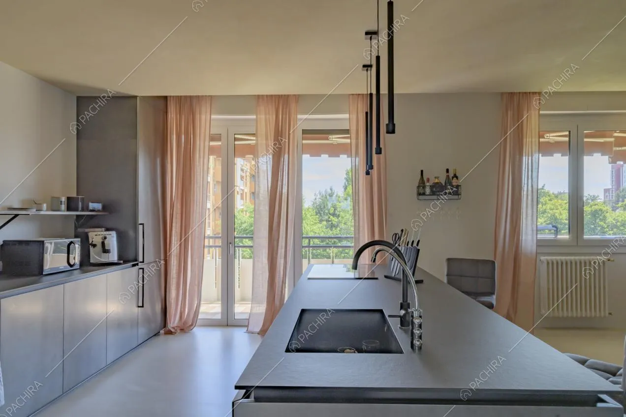 Isola nera della cucina, vista sulla porta-finestra da cui si accede alla terrazza