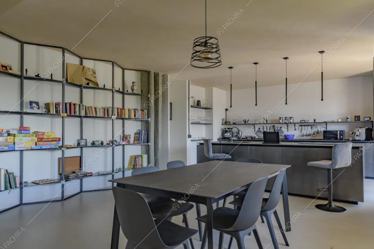 Tavolo da pranzo nero nel salone con lampadario e libreria di design