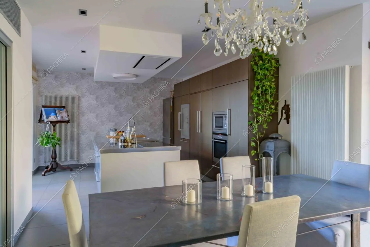 Tavolo da pranzo grigio nella cucina a isola con carta da parati