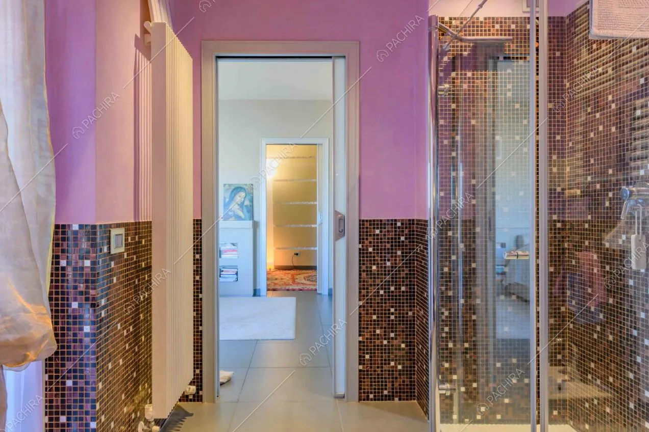 Dal bagno dalle pareti viola vista sulla camera e sul corridoio