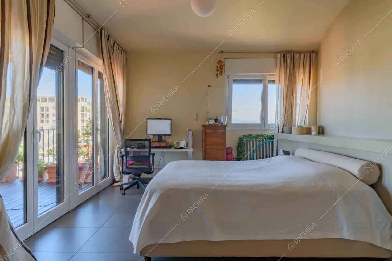 Camera da letto matrimoniale con scrivania e porte-finestre per accedere alla terrazza