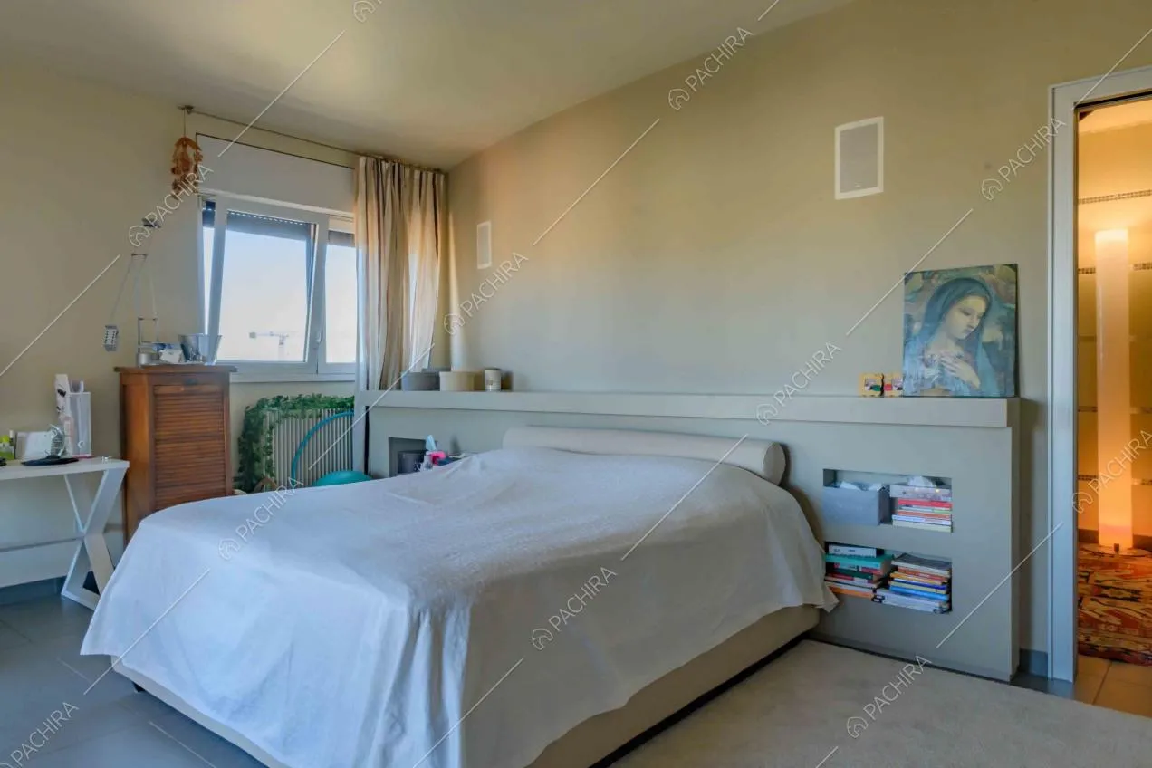 Camera da letto matrimoniale con pavimento in gres e scorcio sul corridoio
