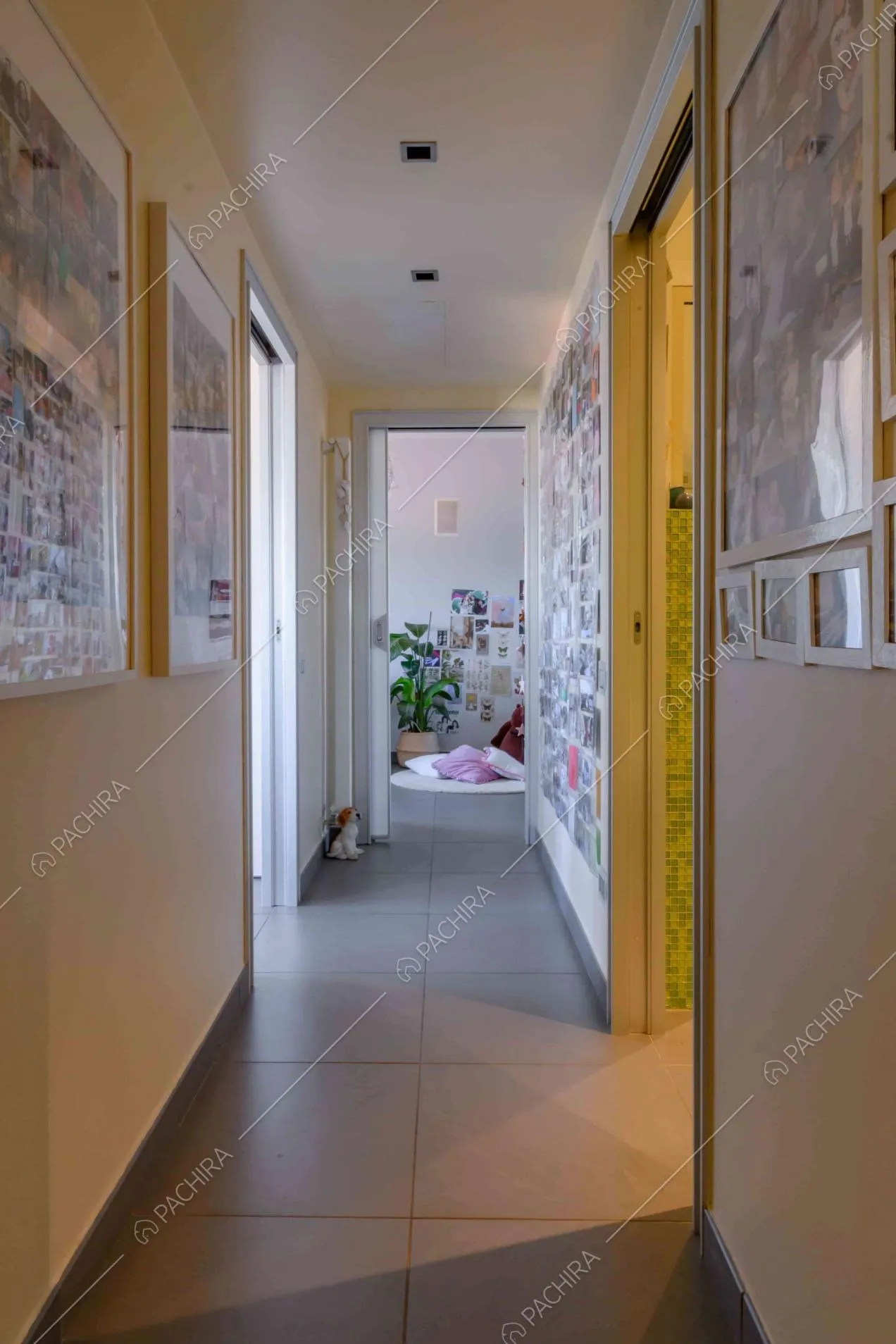 Corridoio con pavimento in gres grigio e pareti con fotografie