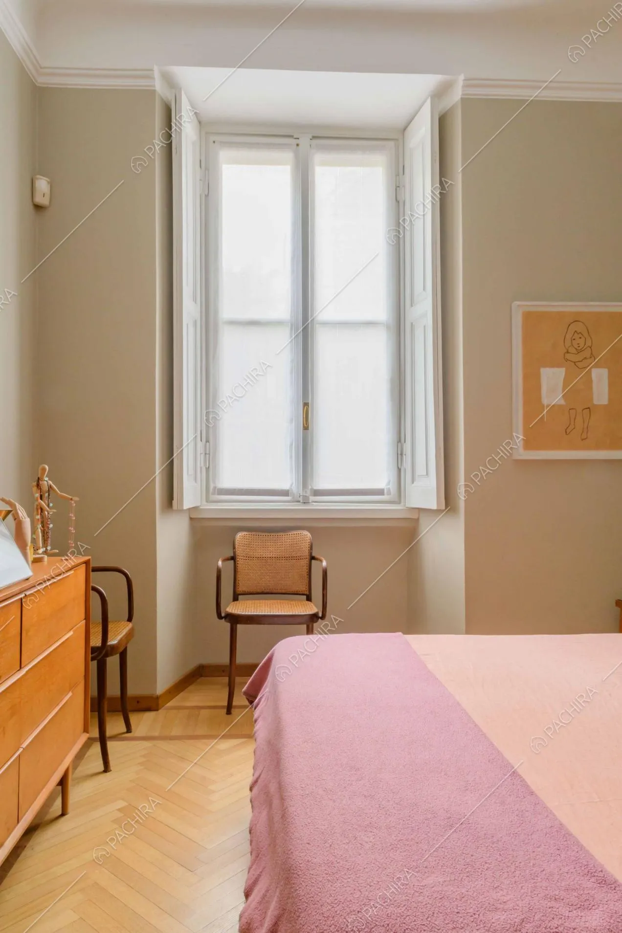 Pareti beige, pavimento in parquet a spina di pesce e grande finestra nella camera da letto matrimoniale