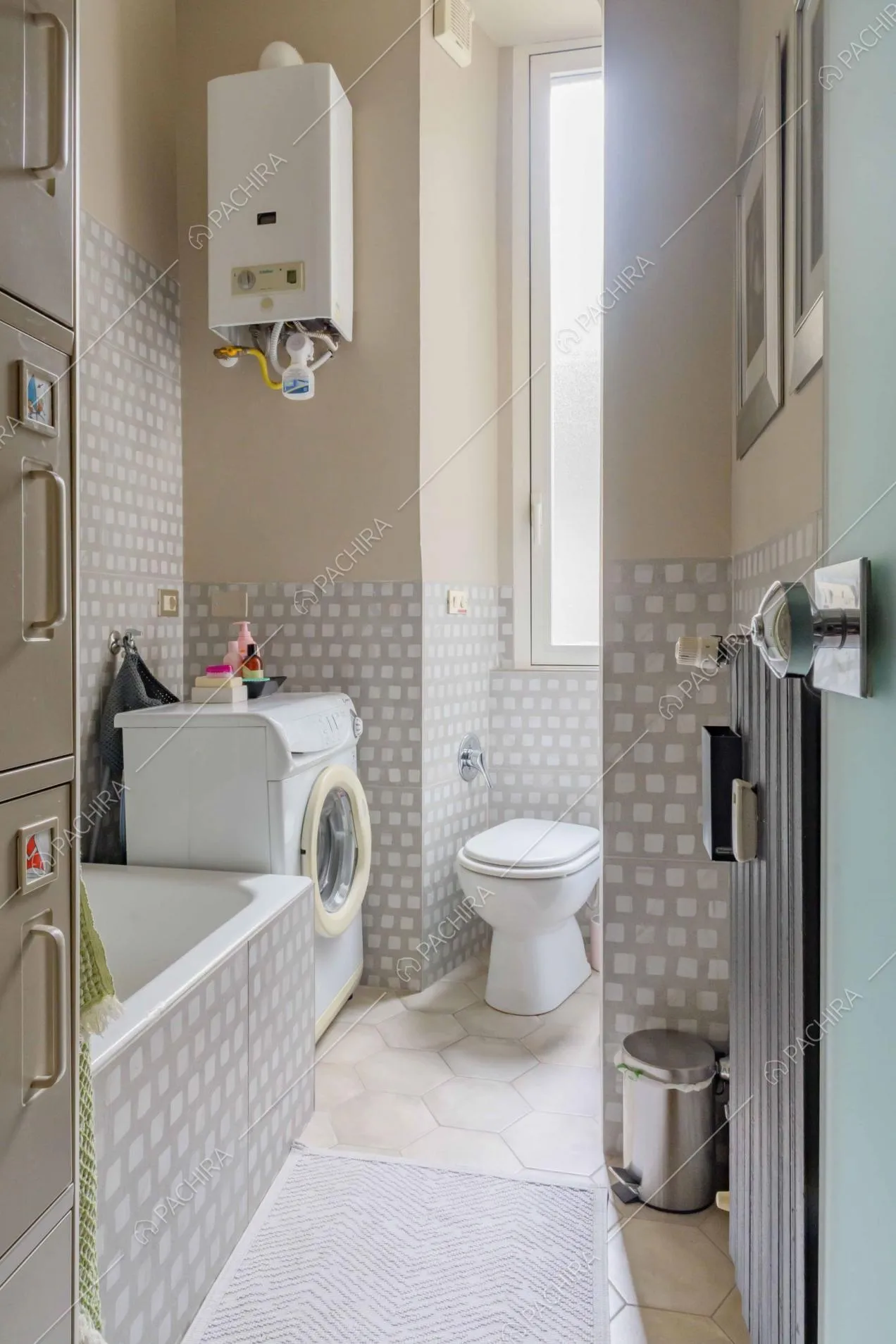 Bagno con vasca, pareti con fantasia grigia e bianca e pavimento in cementine