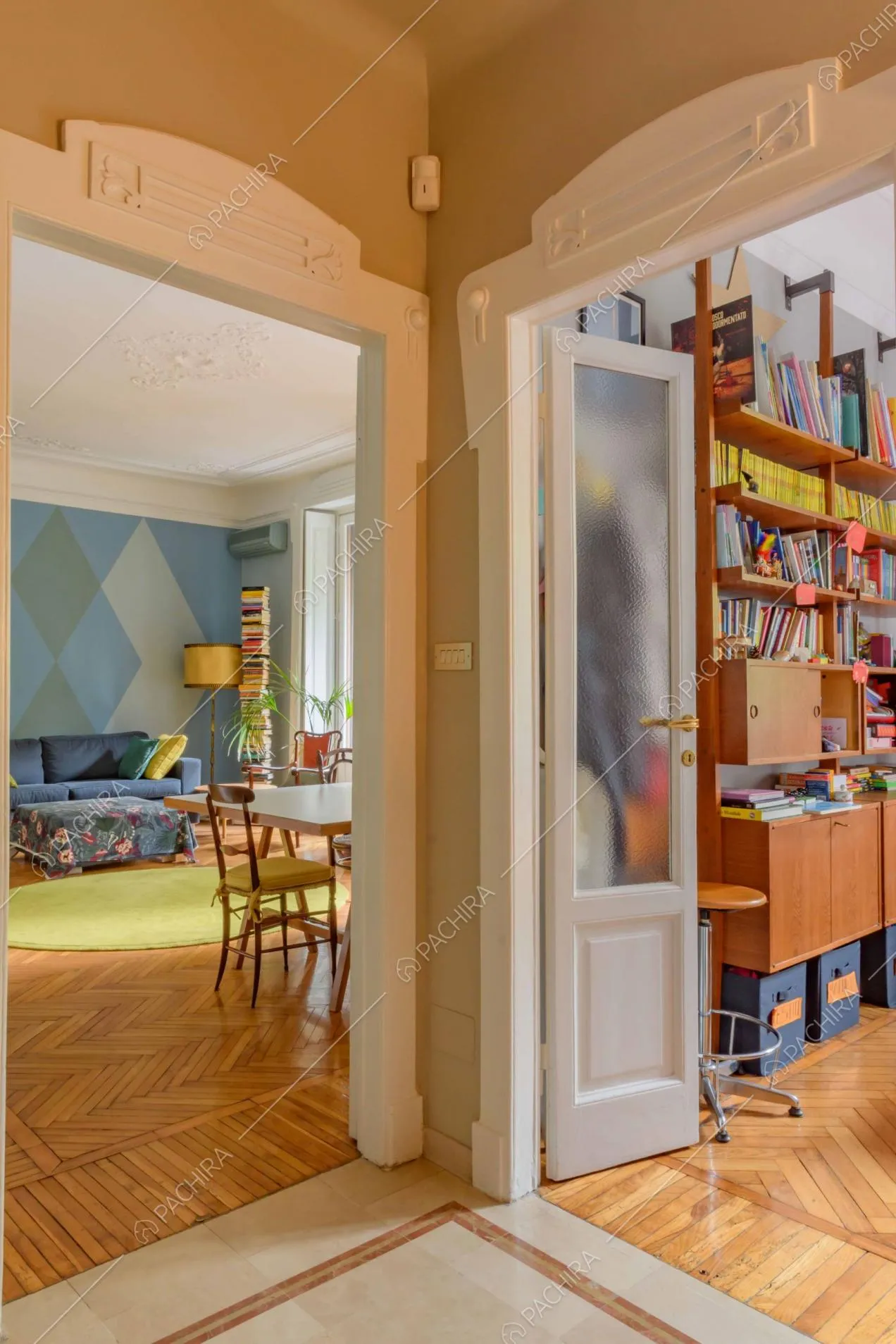 Dall'atrio scorcio sulla camera da letto e sulla sala con boiserie sul soffitto e pavimento in parquet